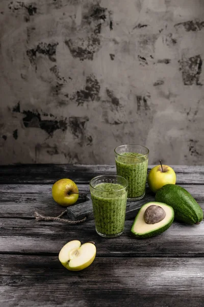 Свежий здоровый смузи на деревенском столе с яблоками и авокадо — стоковое фото