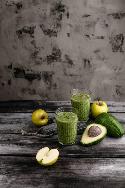 Batido fresco y saludable en mesa rústica con manzanas y aguacate - foto de stock