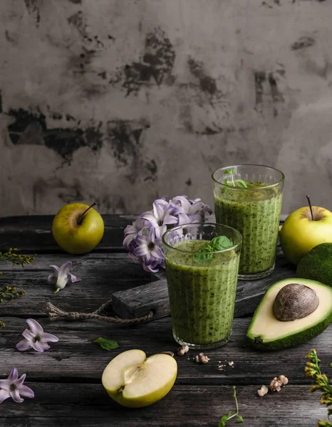 Delicioso smoothie desintoxicação em tábua de madeira rústica com frutas e flores — Fotografia de Stock