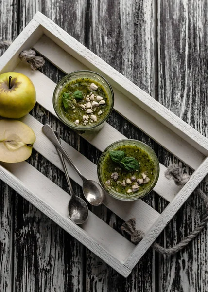 Delicioso smoothie verde em óculos em tábua de madeira rústica — Fotografia de Stock