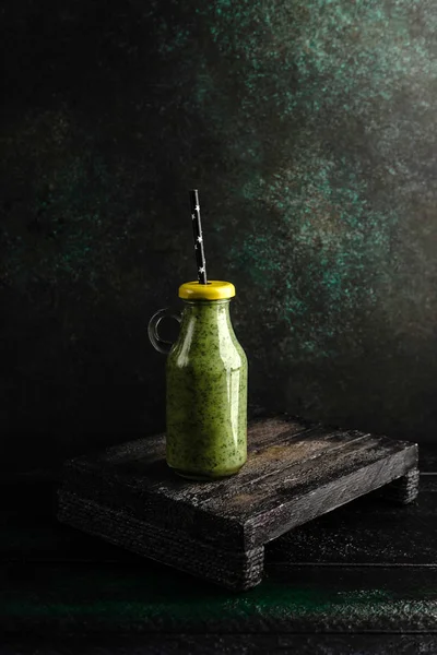 Delizioso frullato disintossicante in bottiglia con coperchio su tavola di legno rustico — Foto stock