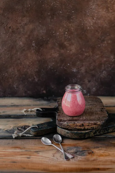 Frullato di bacche biologiche in vaso su fondo di legno — Foto stock