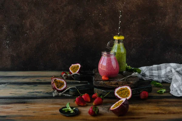 Frische gesunde Smoothies auf rustikalem Tisch mit Beeren und Maracuja — Stockfoto