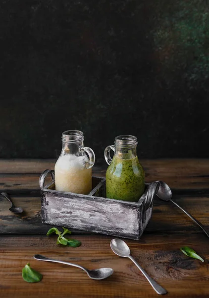 Smoothies verts et blancs bio sur fond bois — Photo de stock