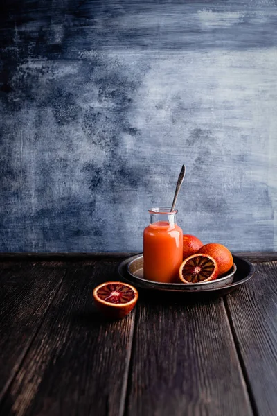 Delicious detox smoothie on rustic wooden board with blood oranges — Stock Photo