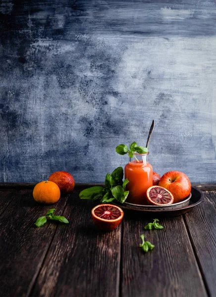 Jugo de naranjas de sangre orgánica en vidrio sobre fondo de madera — Stock Photo