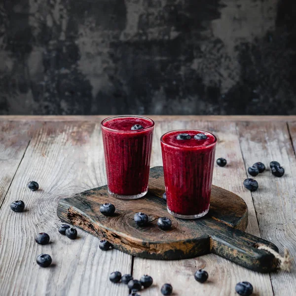 Fresh healthy berry smoothie in glasses on rustic table — Stock Photo