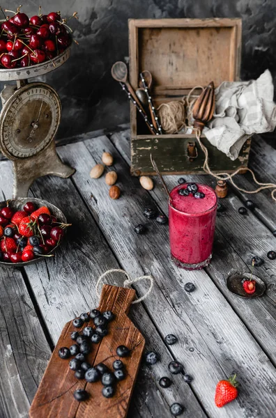 Frischer gesunder Smoothie im Glas auf rustikalem Tisch mit Sommerbeeren — Stockfoto