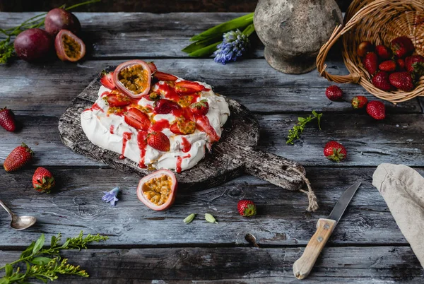 Saboroso bolo de merengue de morango e maracujá na mesa de madeira — Fotografia de Stock