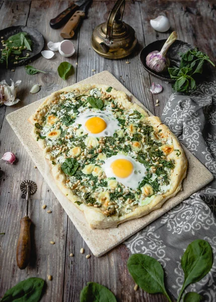 Deliciosa pizza caseira com ovos e ervas na tábua de madeira — Fotografia de Stock