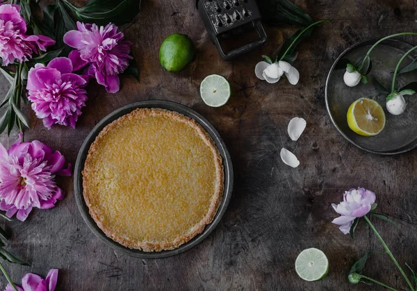 Vista superior de torta de limão saborosa e peônias violetas na mesa de madeira — Fotografia de Stock