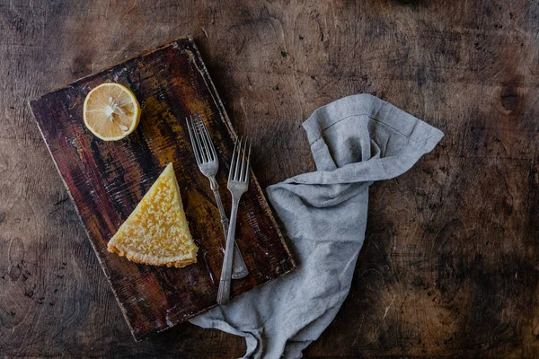 Erhöhte Ansicht des Stücks leckerer Zitronenkuchen auf dem Schneidebrett — Stockfoto