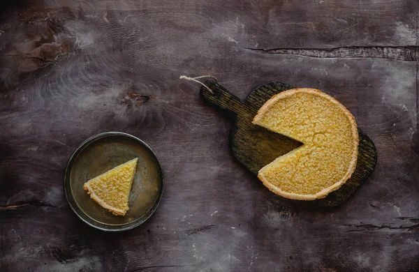 Top view of tasty lemon pie on wooden board and plate — Stock Photo