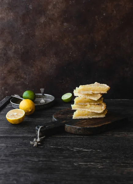 Trozos de delicioso pastel de limón en la tabla de cortar - foto de stock