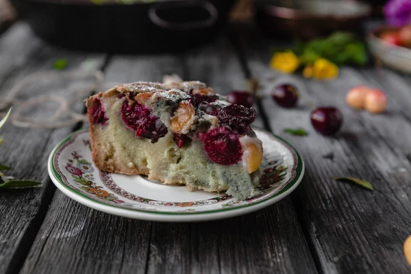 Pedaço de bolo saboroso com bagas e frutas no prato na mesa — Fotografia de Stock