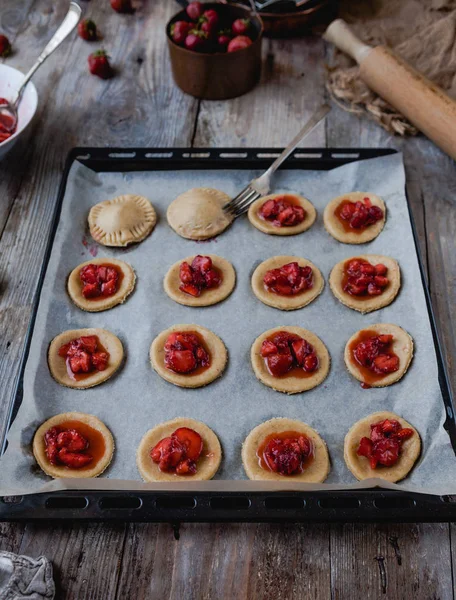 Unprocessed cookies with strawberries and fork on tray — Stock Photo