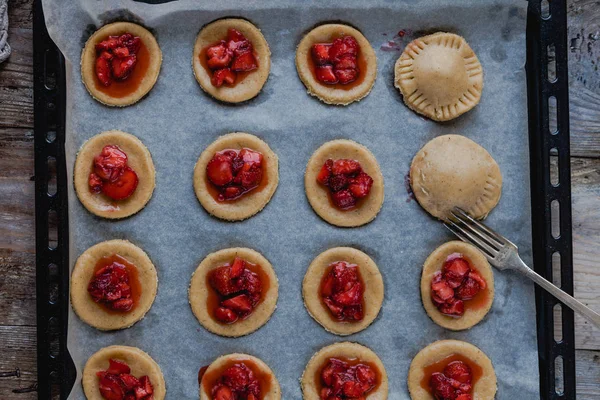 Draufsicht über die Zubereitung von Plätzchen mit Erdbeeren auf Tablett — Stockfoto