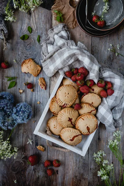 Vista superior de biscoitos saborosos com morangos na bandeja na mesa — Fotografia de Stock