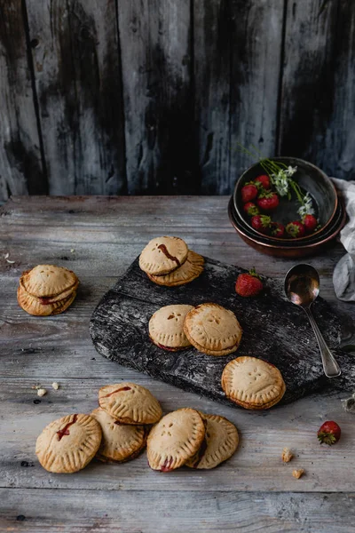 Vista di angolo alto di biscotti saporiti con fragole su tavolo di legno — Foto stock