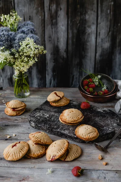 Deliciosas galletas con fresas en mesa de madera - foto de stock