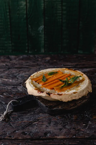 Torta gostosa com cenouras e ervas na mesa de madeira — Fotografia de Stock