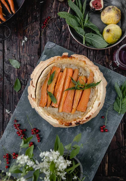 Erhöhter Blick auf gekochte leckere Torte mit Karotten und Kräutern auf Holztisch — Stockfoto