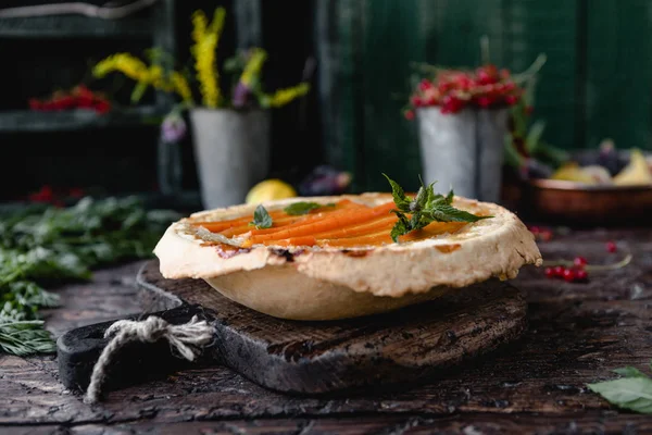 Foco seletivo de torta saborosa com cenouras e ervas na mesa de madeira — Fotografia de Stock