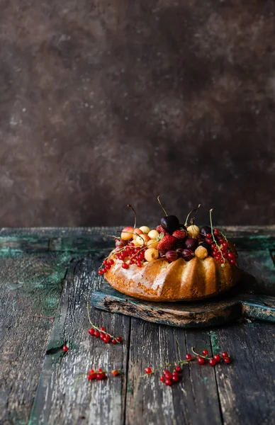 Appetitliche Torte mit Erdbeeren und Johannisbeeren auf Holztisch — Stockfoto