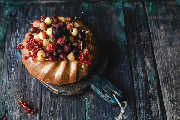 Gâteau savoureux avec fruits et baies sur planche à découper — Photo de stock