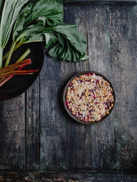 Erhöhter Blick auf leckeren Kuchen mit Beeren und Rhabarber auf Holztablett — Stockfoto