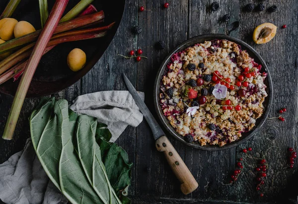 Vue de dessus de tarte savoureuse aux baies et rhubarbe sur table en bois — Photo de stock