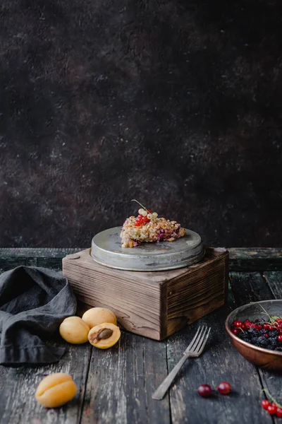 Morceau de tarte savoureuse avec des baies sur des stands sur la table — Photo de stock