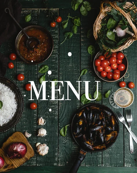 Top view of cooked mussels with shells served in pan with tomatoes, herbs and wine on wooden table, menu lettering — Stock Photo