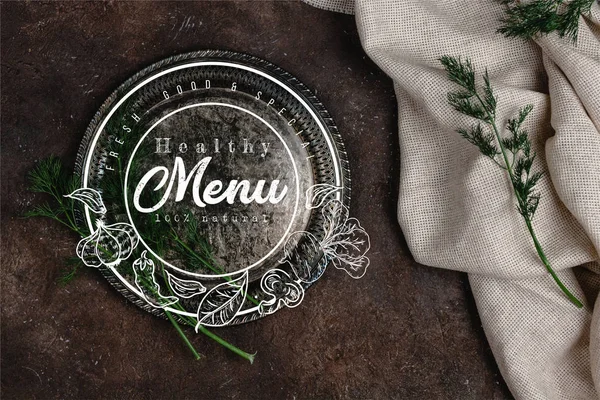 Top view of vintage plate with fennel and tablecloth on dark surface, menu lettering — Stock Photo