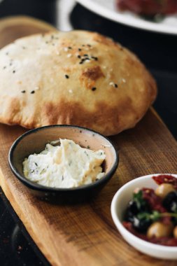 ev yapımı taze ekmek, humus ve zeytin ahşap tahta üzerinde 