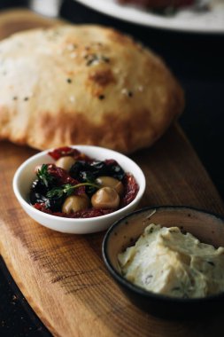 ev yapımı taze ekmek, humus ve zeytin ahşap tahta üzerinde 