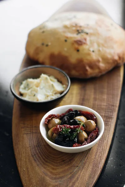 ev yapımı taze ekmek, humus ve zeytin ahşap tahta üzerinde 