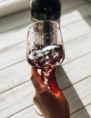 kadın el ile kırmızı şarap kadehinin kafede masada tutarak 