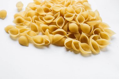 Beyaz arka plan üzerinde pişmemiş makarna yığını    