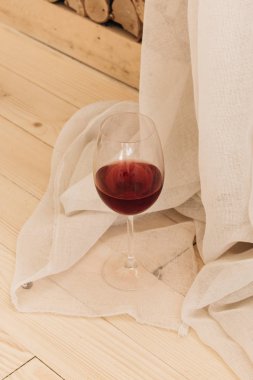 kadehinin ahşap masa ve beyaz Tekstil kırmızı şarap ile 