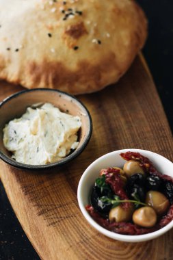 ev yapımı taze ekmek, humus ve zeytin ahşap tahta üzerinde 