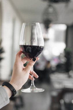 kadın el ile kırmızı şarap kadehinin kafede masada tutarak 