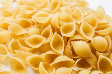 Beyaz arka plan üzerinde pişmemiş makarna yığını    