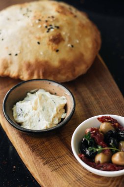 ev yapımı taze ekmek, humus ve zeytin ahşap tahta üzerinde 