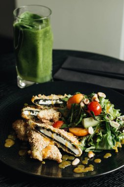 taze yeşil salata ile kraker siyah plaka üzerinde