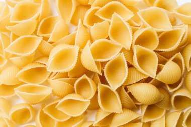 Beyaz arka plan üzerinde pişmemiş makarna yığını    