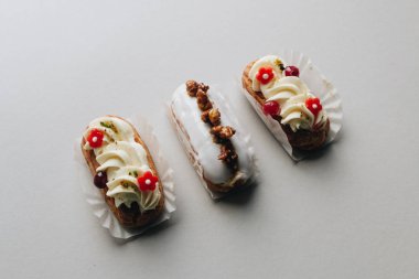 gri arka plan üzerinde üç çeşitli lezzetli tatlılar 