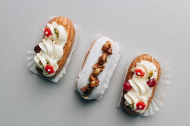 gri arka plan üzerinde üç çeşitli lezzetli tatlılar 