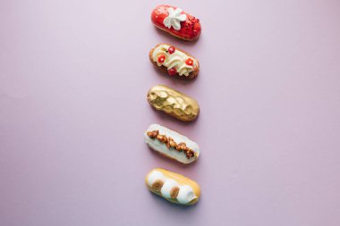 satır çeşitli lezzetli tatlılar mor arka plan, şekerlemeler düz üzerinde yatıyordu kompozisyon 