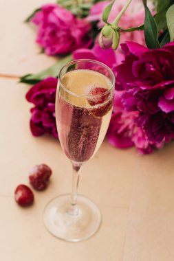 köpüklü şarap ile masaya kiraz, yaz içki, pembe peony çiçek